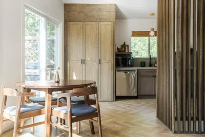 a kitchen with a wooden table and chairs at Modern Designer Cabin, Newly Renovated, EV Charger, Arcade, Kids Bunkbed, Minutes to Lake Arrowhead and Lake Gregory in Twin Peaks