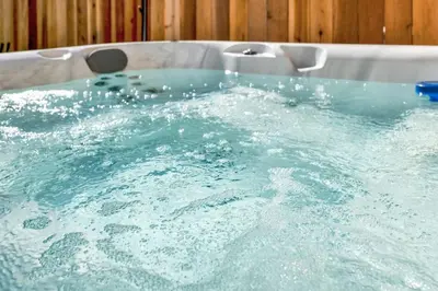 a bath tub filled with lots of blue water at Modern Cottage, Hot Tub, Bistro Patio, Putting Green, Walk to All! in Thousand Oaks