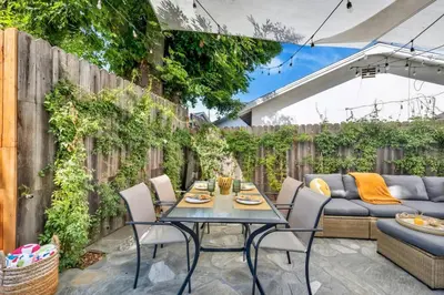 a patio with a table and chairs and a fence at Modern Cottage, Hot Tub, Bistro Patio, Putting Green, Walk to All! in Thousand Oaks