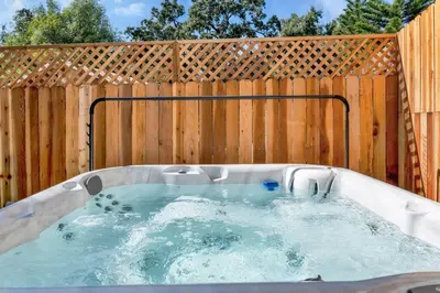 a hot tub in front of a wooden fence at Modern Cottage, Hot Tub, Bistro Patio, Putting Green, Walk to All! in Thousand Oaks