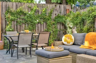 a patio with a couch and chairs and a table at Modern Cottage, Hot Tub, Bistro Patio, Putting Green, Walk to All! in Thousand Oaks