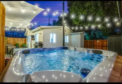 a jacuzzi tub in a backyard at night at Modern Cottage, Hot Tub, Bistro Patio, Putting Green, Walk to All! in Thousand Oaks