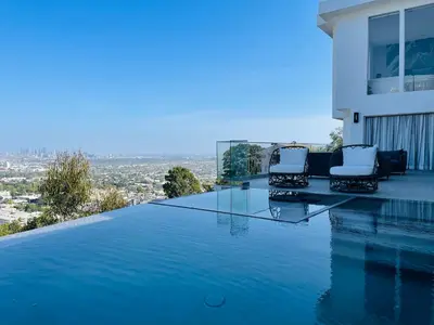a swimming pool with two chairs on the edge of a house at Vista Bliss Retreat-Private Room in Los Angeles