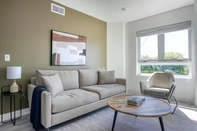 a living room with a couch and a table and a chair at West LA 1br w rooftop gym nr restaurants LAX-1103 in Los Angeles