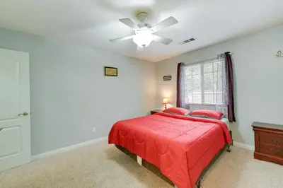 a bedroom with a red bed and a ceiling fan at Porterville Getaway with Patio and Valley Views! in Porterville