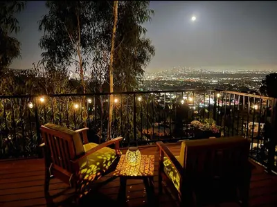 two chairs and a table on a balcony at night at Stunning View Hollywood Hills Guest House in Los Angeles