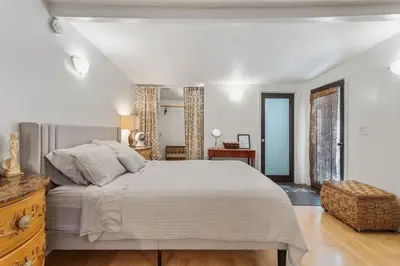 a white bedroom with a large bed and a window at Private Studio City Guest House in Los Angeles