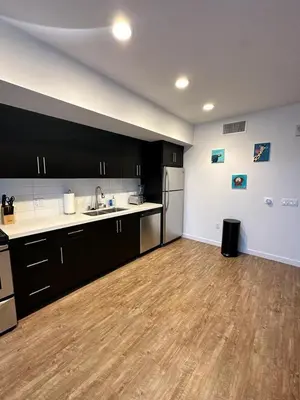 a kitchen with black cabinets and a wooden floor at Studios Universal 10 min drive FREE parking and WIFI in Los Angeles