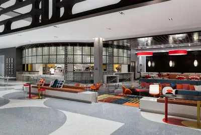 a lobby with couches and chairs in a building at Hilton Buena Park Anaheim in Buena Park