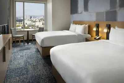 a hotel room with two beds and a table at Courtyard by Marriott Los Angeles L.A. LIVE in Los Angeles