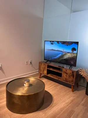 a living room with a coffee table and a flat screen tv at Arion- Cozy Santa Monica getaway steps to the beach Free Parking in Los Angeles