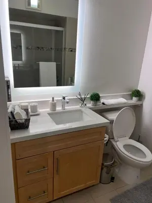 a bathroom with a sink and a toilet and a mirror at Arion- Cozy Santa Monica getaway steps to the beach Free Parking in Los Angeles