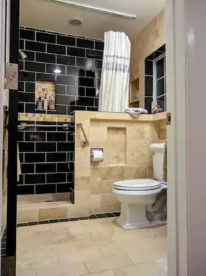 a bathroom with a toilet and a shower with black tiles at Monthly - Cozy 1 Bed Guest Suite near Venice Beach in Los Angeles