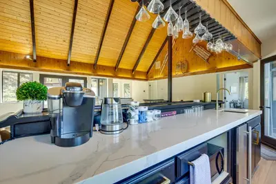 a large kitchen with a counter top and wooden ceilings at 3 Decks, Game Room and Views Lake Arrowhead Home! in Lake Arrowhead