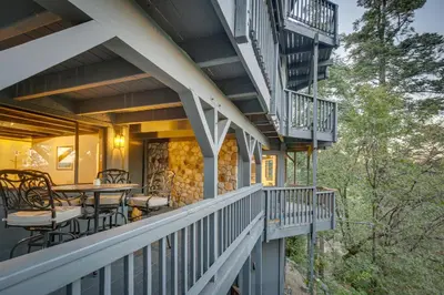 a balcony with tables and chairs on a house at 3 Decks, Game Room and Views Lake Arrowhead Home! in Lake Arrowhead