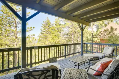 a screened in porch with chairs and tables at 3 Decks, Game Room and Views Lake Arrowhead Home! in Lake Arrowhead