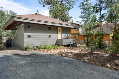 a house with a garage in front of it at Clerestory Cottage - The perfect cozy getaway with a hot tub in Big Bear Lake