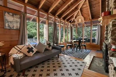 a living room with a couch and a table at Clerestory Cottage - The perfect cozy getaway with a hot tub in Big Bear Lake