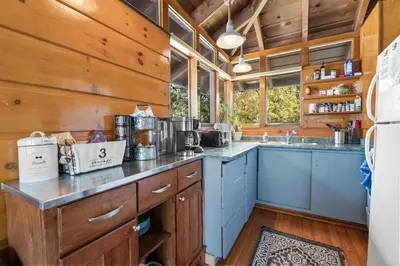 a kitchen with wooden walls and blue cabinets at Clerestory Cottage - The perfect cozy getaway with a hot tub in Big Bear Lake