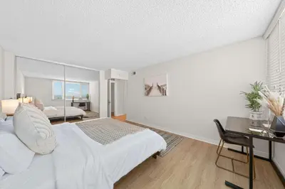 a bedroom with a bed and a desk with a chair at The Lilas-Ocean view Stay high floor Pool Parking in Los Angeles