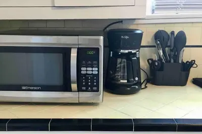 a kitchen counter with a microwave and a coffee maker at Pool Table A C Grill Out Netflix Bikes Yard in Fullerton