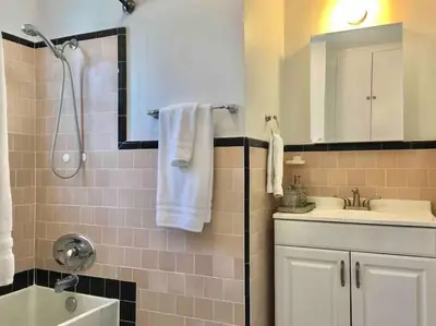 a bathroom with a sink and a shower with white towels at Pool Table A C Grill Out Netflix Bikes Yard in Fullerton