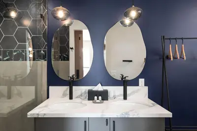 a bathroom with two mirrors and a sink at California Inn in Anaheim