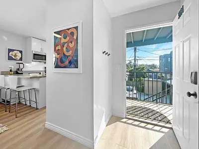 a white apartment with a kitchen and a balcony at Discount For 30 Days Plus Stay In Culver City in Los Angeles