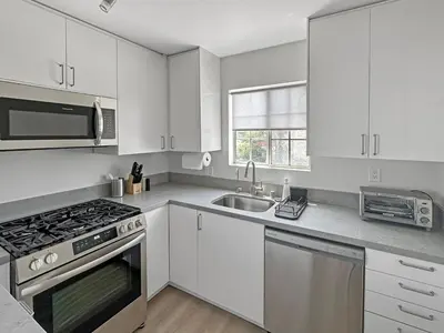 a kitchen with white cabinets and a sink and a stove at Discount For 30 Days Plus Stay In Culver City in Los Angeles