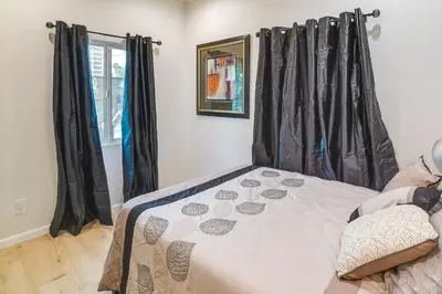 a bedroom with black curtains and a bed at Pet-Friendly Riverside Vacation Rental with Patio! in Riverside