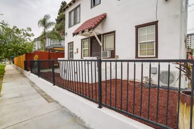 a black fence in front of a white house at Pet-Friendly Riverside Vacation Rental with Patio! in Riverside