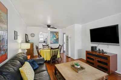 a living room with a couch and a flat screen tv at Walk to Retro Row Long Beach Condo in Long Beach