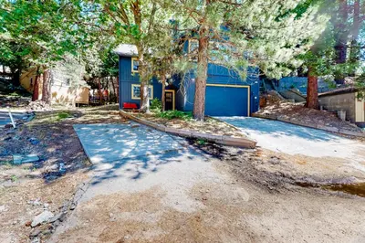 a yard with a blue house with a garage at Lake Gregory Escape in Crestline