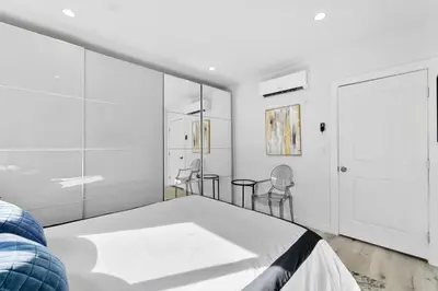 a white bedroom with a bed and chairs at Muirfield Chic City Bungalow with Parking 1,2,3 in Los Angeles