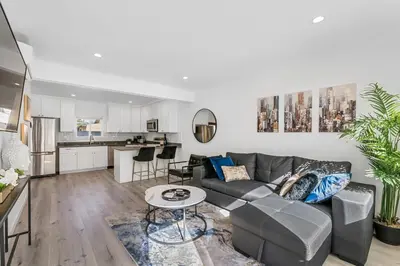 a living room with a couch and a table at Muirfield Chic City Bungalow with Parking 1,2,3 in Los Angeles