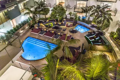 an overhead view of a hotel pool with chairs and umbrellas at Beverly Grove Chic City Oasis 2 BR Apt with Den 138 in Los Angeles