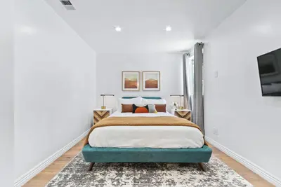 a white bedroom with a bed and a tv at Universal Studios Villa with Pool & Guesthouse in Los Angeles