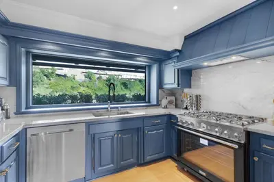 a kitchen with blue cabinets and a window at Beverly Tree House in Los Angeles