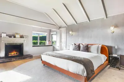 a bedroom with a large bed and a fireplace at Beverly Tree House in Los Angeles