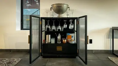 a black cabinet with glasses and a trophy on top at NEW Luxury Concrete Home Just Minutes from the Beach in Long Beach