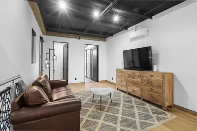 a living room with a couch and a tv at NEW Luxury Concrete Home Just Minutes from the Beach in Long Beach