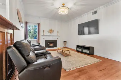 a living room with a leather couch and a television at Oaks Garden in Thousand Oaks