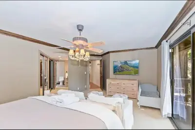 a bedroom with a large bed and a ceiling fan at Arrowhead Lake Cabin pool table stunning views in Lake Arrowhead