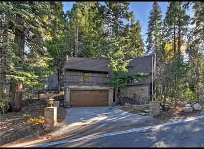 a large house with a garage in the woods at Arrowhead Lake Cabin pool table stunning views in Lake Arrowhead