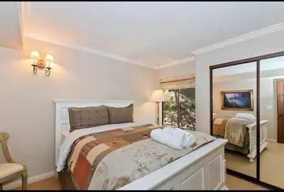 a white bedroom with a bed and a mirror at Arrowhead Lake Cabin pool table stunning views in Lake Arrowhead