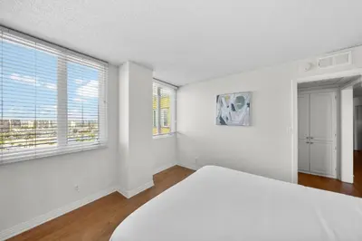a white bedroom with a bed and two windows at Garnet Glow Full Ocean and Venice Beach view 3BR in Los Angeles