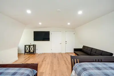 a living room with a couch and a flat screen tv at Modern Pine Mountain Club Cabin with Community Pool! in Pine Mountain Club