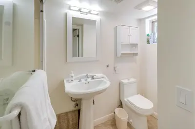 a white bathroom with a sink and a toilet at Modern Pine Mountain Club Cabin with Community Pool! in Pine Mountain Club