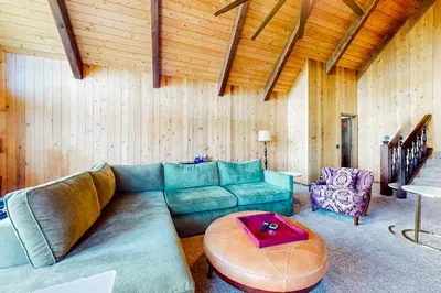 a living room with a couch and a table at Jackalope Lodge in Lake Arrowhead
