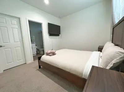 a bedroom with a bed and a table and a door at Modern Lux Home Near Disneyland And In The Heart Of OC! in Santa Ana